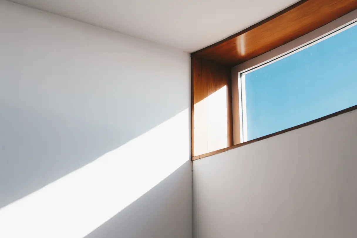 Klares großes Fenster mit Holzrahmen und einfallendem Sonnenlicht